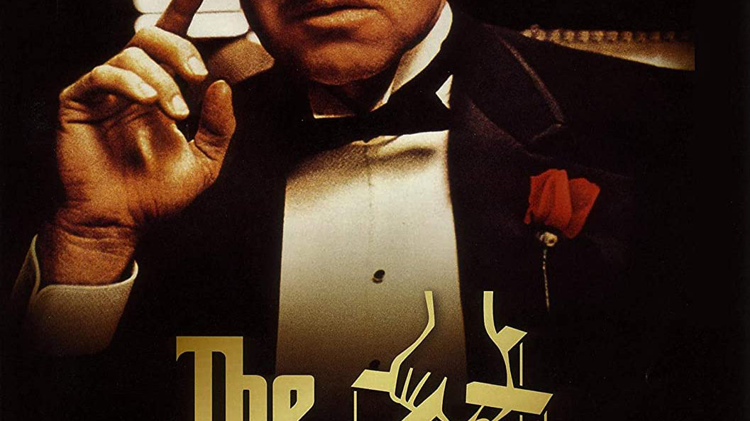 The Godfather Movie Poster with Marlon Brando as Vito Corleone in a tuxedo with a red rose in the chest pocket on the cover with golden letters 